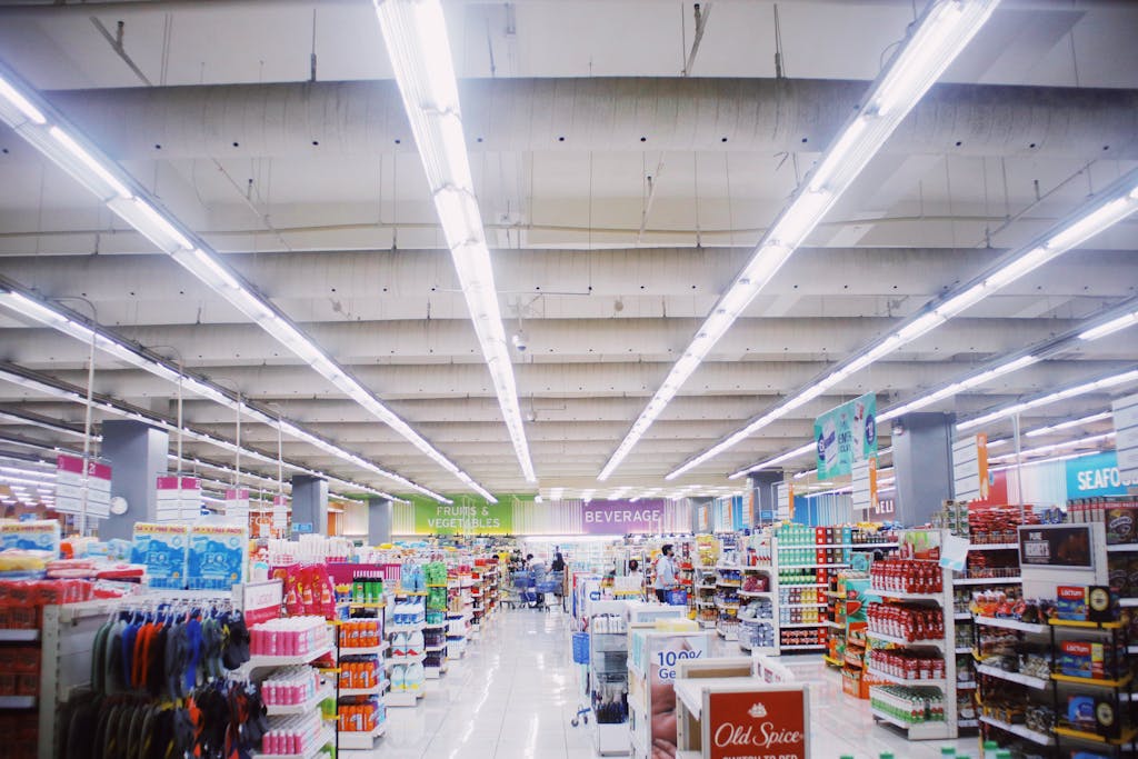 Explore a vibrant and spacious supermarket interior with diverse products and illuminated aisles.